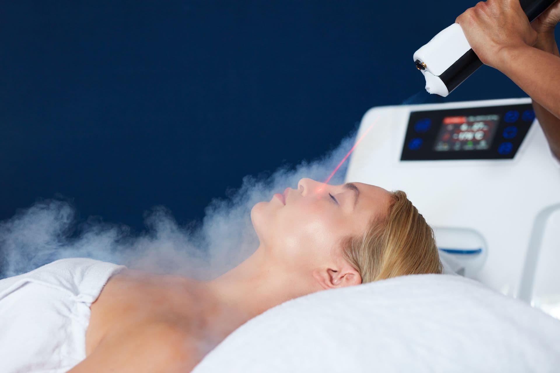Small cryotherapy treatment room with cool light and warm espresso wood floor.